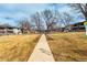Exterior view of the property showcasing manicured lawn and mature trees in a community setting at 5865 E Ithaca Pl, Denver, CO 80237