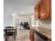 Kitchen with updated appliances, granite countertops, and a view into a living area with desk and fireplace at 5865 E Ithaca Pl, Denver, CO 80237