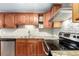 Well-equipped kitchen featuring stainless steel appliances, granite countertops, and cherry wood cabinets for a modern cooking space at 5865 E Ithaca Pl, Denver, CO 80237
