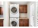 Modern laundry area with stacked washer/dryer, granite countertops, and custom cabinets at 5865 E Ithaca Pl, Denver, CO 80237