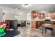 Open-concept living area with kitchen view, stone fireplace, comfortable seating, and modern flooring at 5865 E Ithaca Pl, Denver, CO 80237
