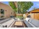Comfortable backyard patio with gray outdoor seating, wooden table, barbecue grill, and a fenced yard for relaxation at 430 Osceola St, Denver, CO 80204