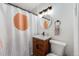 Modern bathroom showcasing a stylish vanity with a unique shower curtain, complemented by sleek fixtures and a minimalist design at 430 Osceola St, Denver, CO 80204