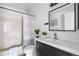 Well-lit bathroom with modern vanity and shower with curtain at 13040 W 63Rd Pl # C, Arvada, CO 80004