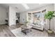 Living room with large windows, modern furniture, with kitchen and front door in the background at 13040 W 63Rd Pl # C, Arvada, CO 80004