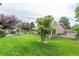 Spacious backyard with mature trees, green lawn, and a charming shed at 7719 S Jackson Cir, Centennial, CO 80122