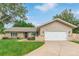 Charming home with a well-manicured lawn, blue front door, and a two-car garage at 7719 S Jackson Cir, Centennial, CO 80122