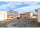 View of the backyard with a brick garage and dirt ground at 11624 Claude Ct, Northglenn, CO 80233