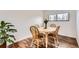 Cozy dining area with a round wooden table and four chairs, illuminated by natural light from a nearby window at 789 Hamal Dr, Lone Tree, CO 80124