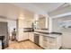 Bright kitchen featuring white cabinets, stainless steel appliances, and hardwood floors leading to a dining area at 789 Hamal Dr, Lone Tree, CO 80124