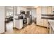 Well-lit kitchen features stainless steel appliances, white cabinets, and hardwood floors at 789 Hamal Dr, Lone Tree, CO 80124