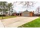 Charming red brick ranch-style home featuring an attached two car garage, a large front yard, and mature shade trees at 699 S Oswego St, Aurora, CO 80012