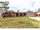 Charming red brick ranch-style home with covered entryway, attached two-car garage, and bay window at 699 S Oswego St, Aurora, CO 80012