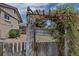 Landscaped backyard featuring a wooden pergola-covered entrance, and wood fencing around the yard at 3630 W Saratoga Ave, Littleton, CO 80123