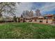 Sprawling backyard with mature trees, brick patio, grill, and detached covered outdoor dining area at 3630 W Saratoga Ave, Littleton, CO 80123