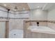 This luxurious bathroom features a walk-in shower with multiple shower heads and a soaking tub at 3630 W Saratoga Ave, Littleton, CO 80123