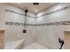 Tiled walk-in shower with a bench, overhead shower head, and decorative tile accents at 3630 W Saratoga Ave, Littleton, CO 80123