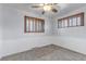 This spacious bedroom has neutral carpet, a chair rail, and two windows with wood trim at 3630 W Saratoga Ave, Littleton, CO 80123