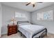 Comfortable bedroom with neutral walls, carpet flooring, a ceiling fan and two bright windows at 3630 W Saratoga Ave, Littleton, CO 80123