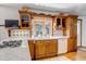 Charming kitchen featuring white tile countertops, custom wood cabinets, and a corner window for natural light at 3630 W Saratoga Ave, Littleton, CO 80123