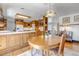 Traditional eat-in kitchen with custom wood cabinets, hardwood floors, and decorative pendant lighting at 3630 W Saratoga Ave, Littleton, CO 80123