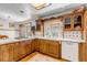 This kitchen showcases unique wood cabinets, white countertops, and a bay window at 3630 W Saratoga Ave, Littleton, CO 80123