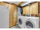 The laundry room has washer, dryer, storage cabinets, and a utility sink at 3630 W Saratoga Ave, Littleton, CO 80123