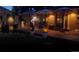 Evening view of a brick patio with outdoor seating, umbrellas, and illuminated decor, creating a cozy ambiance at 3630 W Saratoga Ave, Littleton, CO 80123