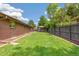 Spacious backyard with lush green lawn, a wooden pergola, and a privacy fence, ideal for outdoor activities and relaxation at 12256 W 34Th Pl, Wheat Ridge, CO 80033