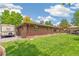 Spacious backyard showcasing well-maintained lawn, brick exterior, and a covered dining area, ideal for outdoor activities at 12256 W 34Th Pl, Wheat Ridge, CO 80033