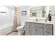 Modern bathroom features a stylish vanity, a toilet and a shower-tub combination with a unique shower curtain at 12256 W 34Th Pl, Wheat Ridge, CO 80033