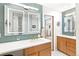 Well lit bathroom featuring dual vanity, wood cabinets, white countertop, and modern fixtures at 12256 W 34Th Pl, Wheat Ridge, CO 80033