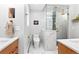 Modern bathroom with marble tile, glass-enclosed shower, and wood vanity with white countertop at 12256 W 34Th Pl, Wheat Ridge, CO 80033