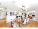 Light filled dining room with wood floors, stylish chandelier, and access to kitchen and living room at 12256 W 34Th Pl, Wheat Ridge, CO 80033