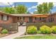 Inviting front porch with stylish outdoor seating, green fence, and lovely landscaping at 12256 W 34Th Pl, Wheat Ridge, CO 80033