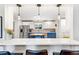 Bright, open kitchen with stainless steel appliances, white cabinetry, and a marble countertop bar at 12256 W 34Th Pl, Wheat Ridge, CO 80033