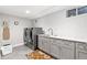 Well-lit laundry room with modern gray cabinets, stainless steel appliances, and a stylish rug at 12256 W 34Th Pl, Wheat Ridge, CO 80033