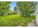 Spacious backyard with green lawn, patio area, mature trees, and storage shed at 6940 W 63Rd Ave, Arvada, CO 80003