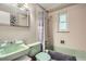 Charming bathroom with a green sink and toilet, alongside a shower-tub combo at 6940 W 63Rd Ave, Arvada, CO 80003