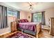 Cozy bedroom featuring hardwood floors, two bright windows with curtains, and a full size bed and dresser at 6940 W 63Rd Ave, Arvada, CO 80003