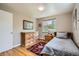 Light bedroom with hardwood floors, a window with blinds, a twin size bed and a wood dresser at 6940 W 63Rd Ave, Arvada, CO 80003