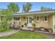 Charming brick ranch home with a cozy front porch and well-manicured landscaping at 6940 W 63Rd Ave, Arvada, CO 80003
