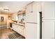 Traditional kitchen features white cabinets, dark countertops and tile floors, and lots of natural light at 6940 W 63Rd Ave, Arvada, CO 80003