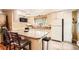 Bright eat-in kitchen features a granite island with seating, updated appliances and cabinets, and tile floors at 6940 W 63Rd Ave, Arvada, CO 80003