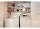 Efficient laundry area with washer, dryer and shelving for storage at 6940 W 63Rd Ave, Arvada, CO 80003