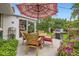 Outdoor patio dining area with umbrella and grill, surrounded by lush greenery at 6940 W 63Rd Ave, Arvada, CO 80003