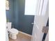 Powder room features neutral tile, calming paint, and a half-view of the door at 7243 S Old Hammer Ct, Aurora, CO 80016