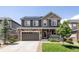 Two-story home with stone accents, solar panels, neutral siding, landscaped yard and a two car garage at 7243 S Old Hammer Ct, Aurora, CO 80016