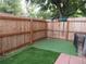 Fenced backyard with artificial grass and garden tools hanging on the fence at 3550 S Harlan St # 313, Denver, CO 80235