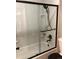 The bathroom featuring a white tub with a black shower head and sliding glass doors at 3550 S Harlan St # 313, Denver, CO 80235